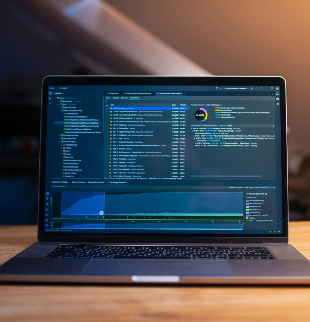 Laptop screen displaying code and data graphs.